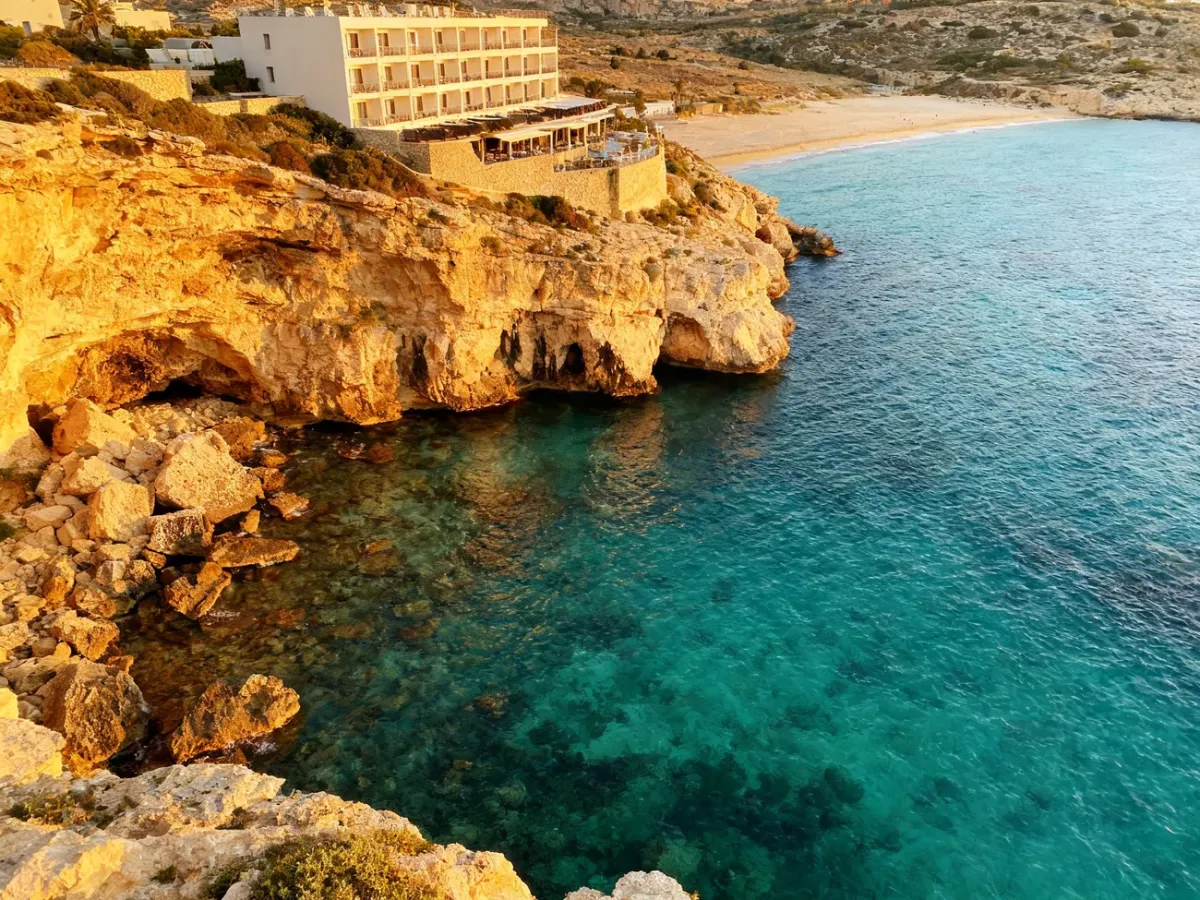 Maltańskie wybrzeże z hotelami przy skalistym brzegu i piaszczystą plażą w oddali